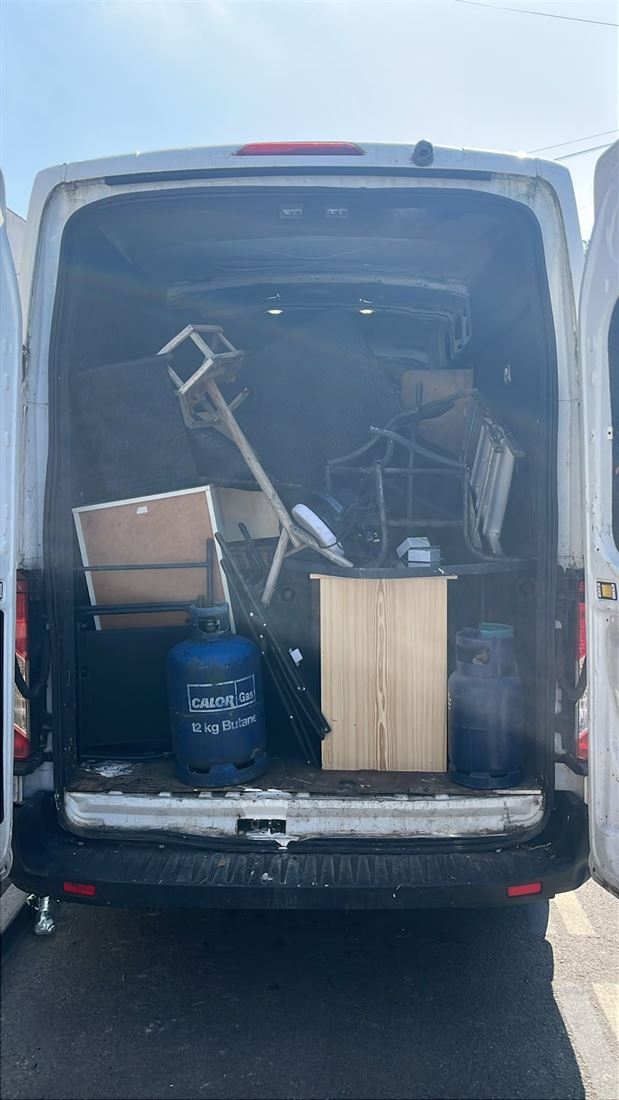 The back of an Alpha Waste Removal van loaded with furniture